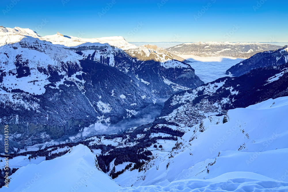 Panoramic view of Lauterbrunnen Valley and Wengen (right), Switzerland on a beautiful morning in winter against blue sky seen from