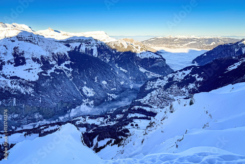 Obraz na płótnie Panoramic view of Lauterbrunnen Valley and Wengen (right), Switzerland on a beautiful morning in winter against blue sky seen from w salonie