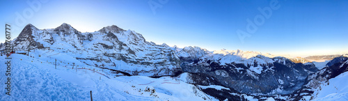Obraz na płótnie Panoramic view of upper Lauberhorn Ski World Cup race course against snowcapped mountains in Wengen, Switzerland on a beautiful morning with blue sky w salonie