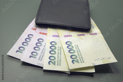 Argentine Money, Currency of Argentine, Pesos argentinos, various bills inside a wallet, close-up on dark background. Twenty thousand pesos cash bills