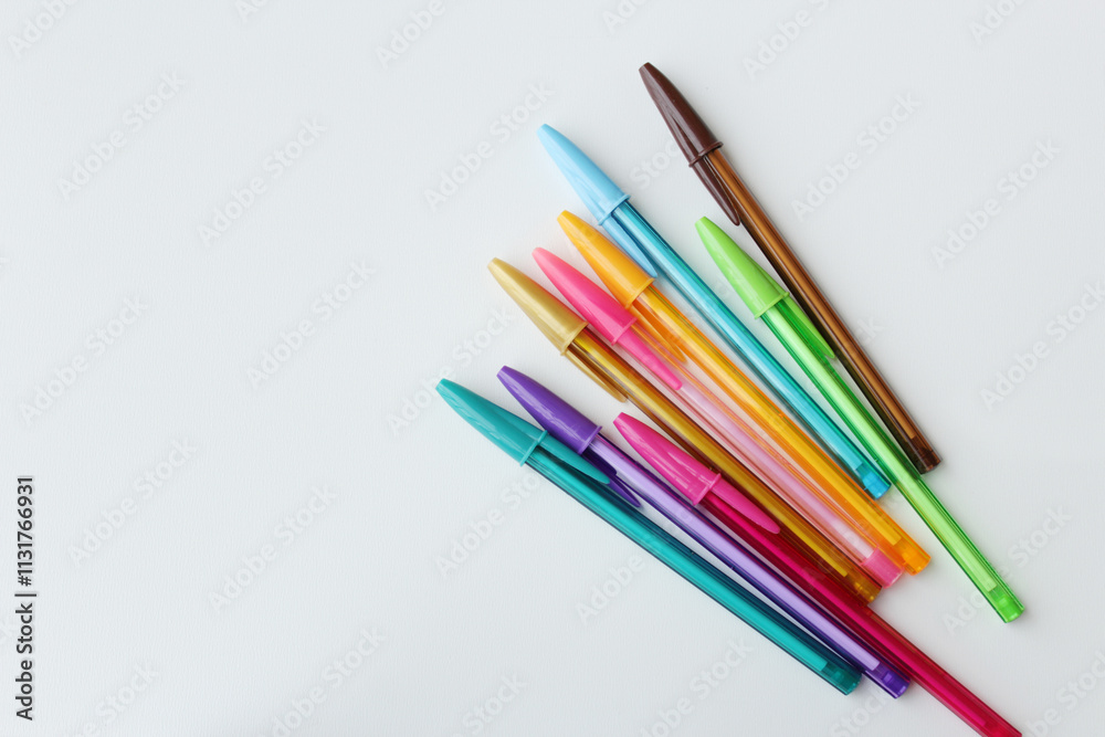 Fototapeta premium Bunch of colorful pens arranged in diagonal on white background. Color stationery, school supplies, art lesson, creativity concept. 