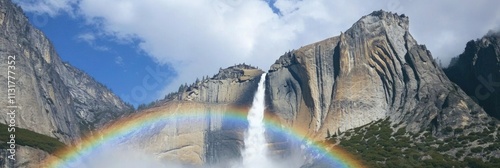 A stunning waterfall cascading down a mountain with a vibrant rainbow arching below.