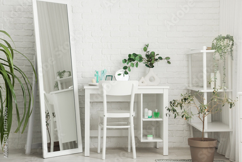 Interior of dressing room with makeup table, shelf unit and plants photo