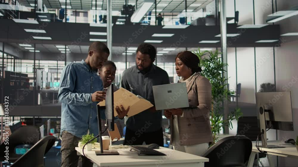 African American team collaborates on a financial planning project in a business space, emphasizing teamwork and data analysis to make informed decisions for future firm growth. Camera B.