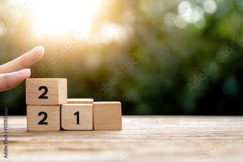 Wooden blocks displaying numbers are arranged on a table as sunlight softly bathes them, hinting at the concepts of progression, dawn, and newfound possibilities. photo