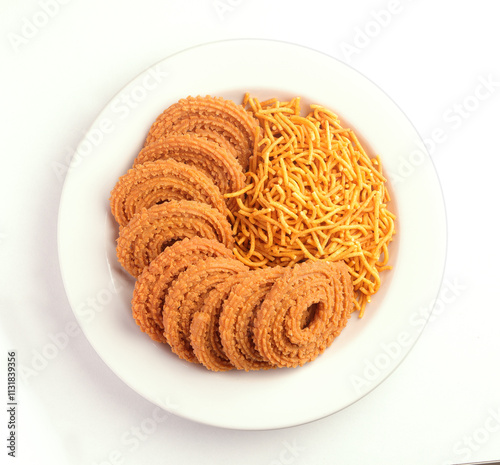 Crunchy fried homemade Chakli in a plate. Chakli and Besan sevis a savory snack from India made out of rice, mixed yellow and green lentils along with spices Diwali festival Indian snack called Chakli photo