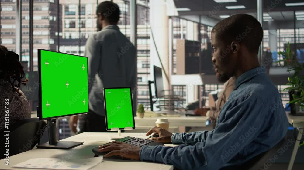 Black businessman analyzing financial data next to chroma key screen, reviewing company strategies on pc and contributing to business development and decision making. Successful forecast. Camera B.