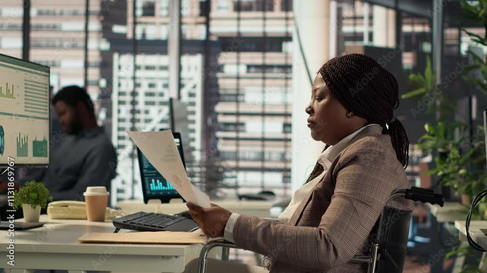 Female boss with chronic disability examining archived files and data reports, creating a financial plan before allocating resources. Businesswoman in wheelchair review infographics. Camera A.