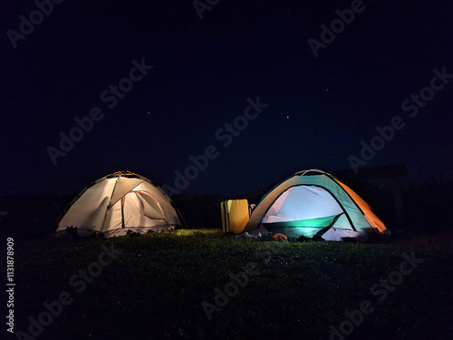 Two vibrant tents pitched at campsite of Nanthaburi National park, Nan Thailand, with sky at midnight. photo