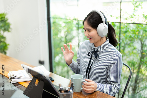 Young Asian business woman employee or executive manager using computer looking at laptop and talking leading online conference remote video call virtual meeting or online training working in office.