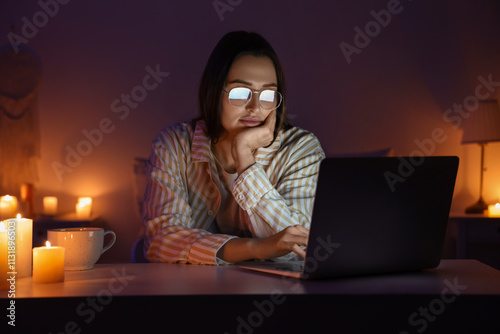 Young woman using laptop at...