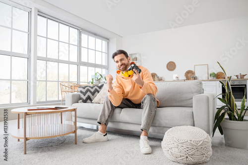 Happy young man playing vid...
