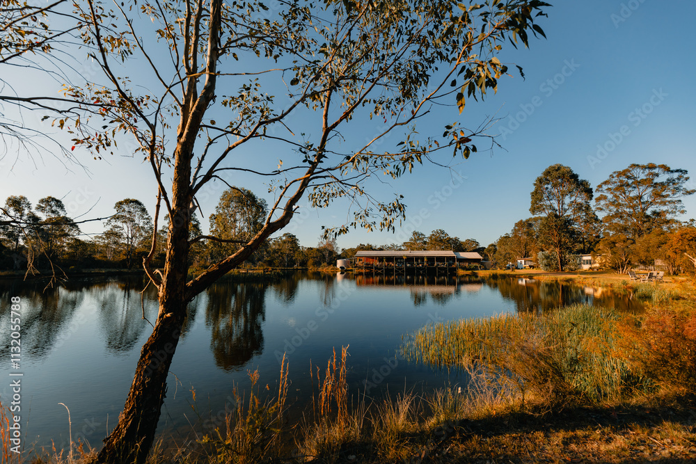 Obraz premium House nestled on small lake with reflection in afternoon sun