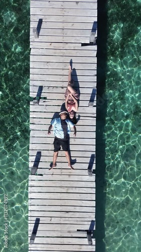 Joyful young Asian couple walking around and enjoying their time on the dock in Labuan Bajo.