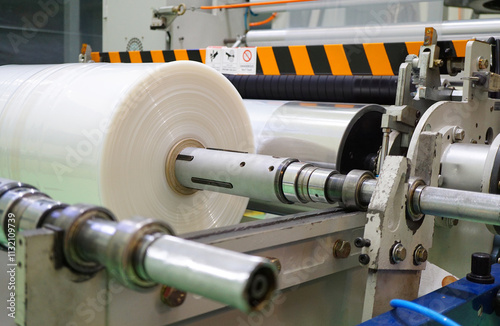 Plastic film roll on winding unit of Blown film plastic bag-making machine.