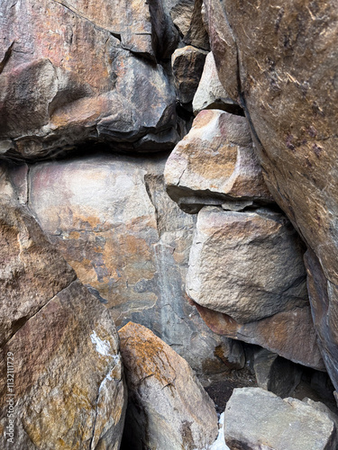 A close-up view of rugged, weathered rocks showcasing intricate textures and earthy tones. The image captures the raw beauty of natural formations.  photo