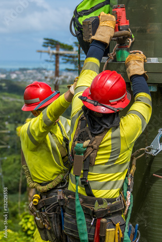 Lineman securing steel pole sections with an impact drill