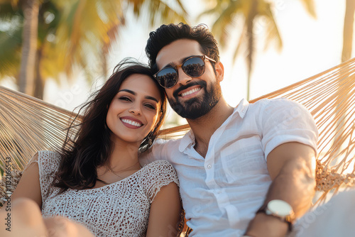 young smart indian couple sitting on a hammock enjoying vacation in luxury resort , They wearing fashionable cloths at luxury resort background photo