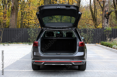 Huge empty trunk of a wagon black car in autumn. Open back door modern car. Car boot is open. Wagon clean trunk. Modern wagon car open trunk. Front view. photo