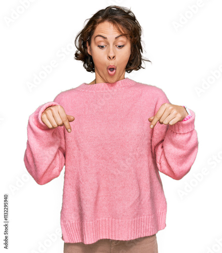 Young hispanic woman wearing casual clothes pointing down with fingers showing advertisement, surprised face and open mouth
