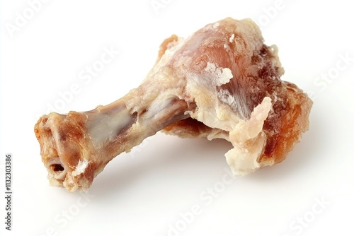 Close-up of a single, gnawed chicken leg bone on a white background. photo