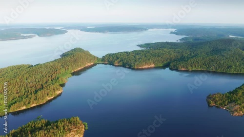 Aerial view on the lake and Islands with rocky coastline and forest in Karelia. Drone view on the beautiful Ladoga lake. Nature landscape scene.