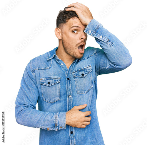 Young hispanic man wearing casual denim jacket surprised with hand on head for mistake, remember error. forgot, bad memory concept. photo