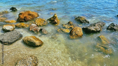 Stone reef ,seashell on sand beach with wave of sea water landscape for decoration on summer holiday and sea life.