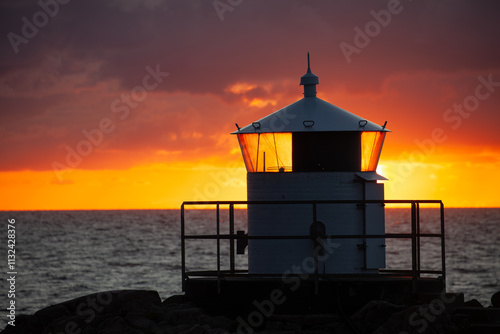 Kullen Västra Lighthouse in Sweden. Red and yellow beautiful sunset. photo