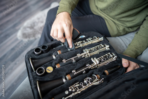 Sticker Man carefully places disassembled clarinet into protective case