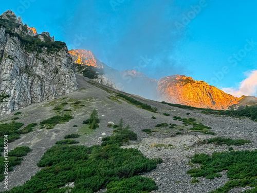 Mountain peak Begunjscica bathed in warm sunrise light seen from Loibl Pass in Karawanks, border Slovenia Austria. Wanderlust in Austrian Slovenian Alps. Tranquil atmosphere in alpine wilderness. Hike photo