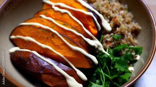 A gourmet Buddha bowl with roasted sweet potato, quinoa, and tahini dressing, plated in the center of a deep ceramic dish.