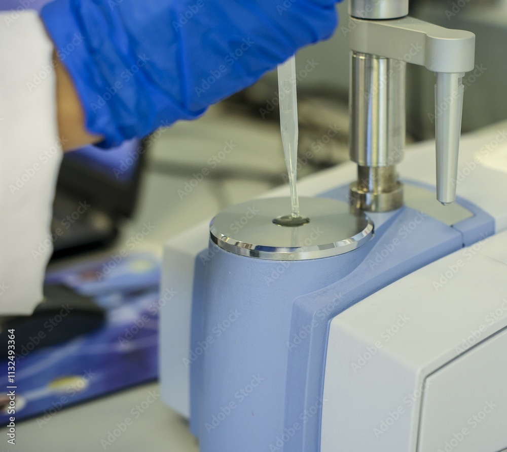 Close-up of a laboratory scientist using a pipette with an advanced FTIR spectrometer for chemical sample analysis. High-tech equipment for precise measurements in research and industrial laboratories