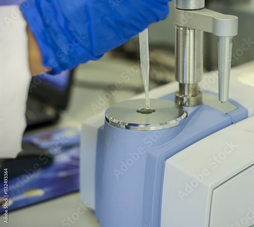 Obraz na płótnie Close-up of a laboratory scientist using a pipette with an advanced FTIR spectrometer for chemical sample analysis. High-tech equipment for precise measurements in research and industrial laboratories w salonie