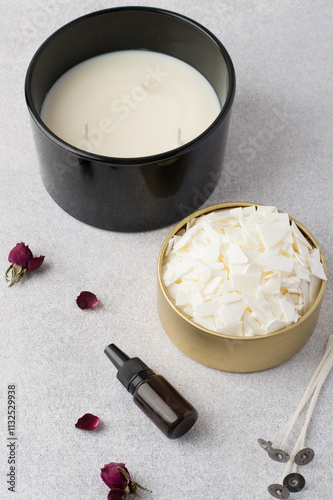 Soy vox in bulk, in a metal container, wicks, aroma oil, rose on a light background. Making handmade candles.