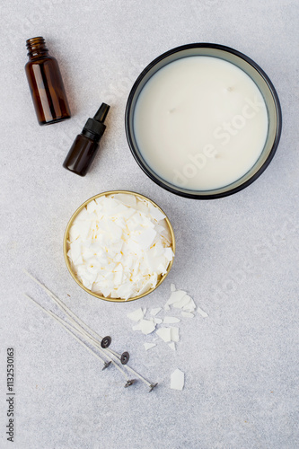 Soy vox in bulk, in a metal container, wicks, aroma oil on a light background. Making handmade candles.