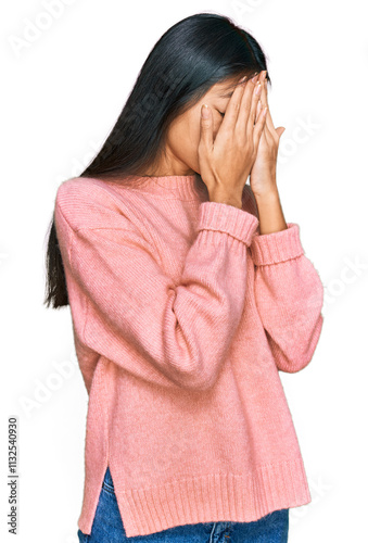Beautiful young asian woman wearing casual winter sweater with sad expression covering face with hands while crying. depression concept.