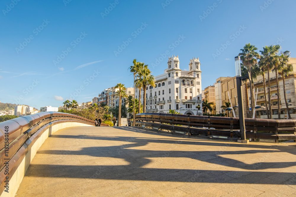 Beautiful street view of Ceuta with Hercules statue shade on the pavement in the foreground, Spain, North Africa