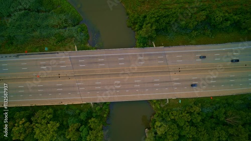 Birds-eye view of cars and trucks traveling on a bridge over a river in southeastern Michigan. photo