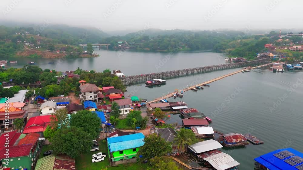 drone above Sangkhlaburi mon village wooden bridge in early morning misty fog atmosphere scenic remote travel destination in Thailand