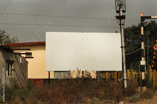 Advertising billboard mockup on the near railway fatak in indian rural areas. Large Hoarding advertising hanging for mockup. Blank white banner for advertisement mounted in india. photo