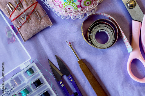 Tailor tools. Crafting essentials for sewing projects on a table with threads, measuring tape and tools. photo