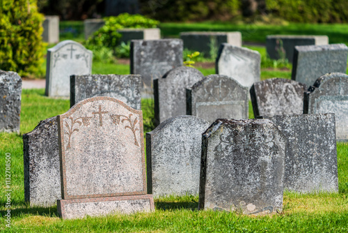 Group of weathered gravestones in sunlight