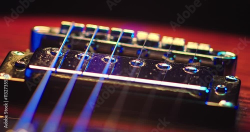 Close-Up of an Electric Guitar. Details of strings, frets, and the body shine under moody lighting. Music, creativity, and rock culture.