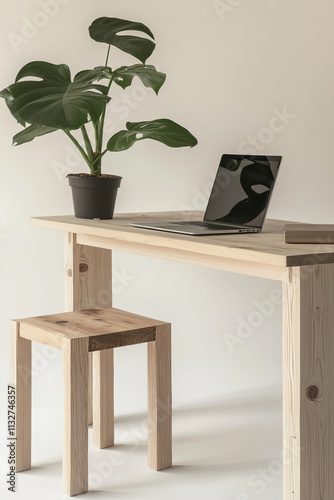 minimalist office setup featuring laptop, wooden table, and plant. serene environment promotes productivity and focus