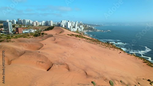 Aerial establishing shot of tourists siting at Concon Dunes looking at the views photo