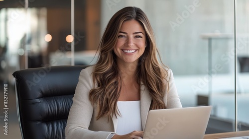 Free Download Smiling businesswoman working on a laptop in modern office - GFXLoad