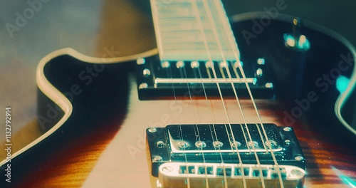 Close-Up of an Electric Guitar. Details of strings, frets, and the body shine under moody lighting. Music, creativity, and rock culture.