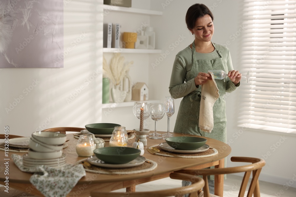 Woman setting table for dinner at home Woman setting table for dinner at home