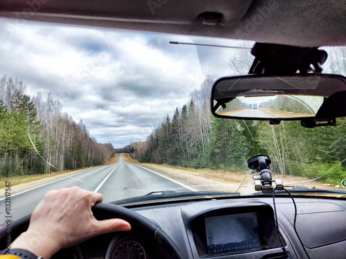 Car salon, windshield, and landscape through damaged windshield. View from seat of driver on nature. The danger of driving a faulty car